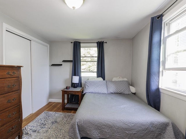bedroom with wood finished floors and a closet