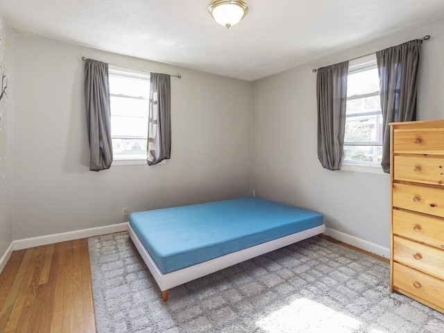 bedroom with baseboards and wood finished floors