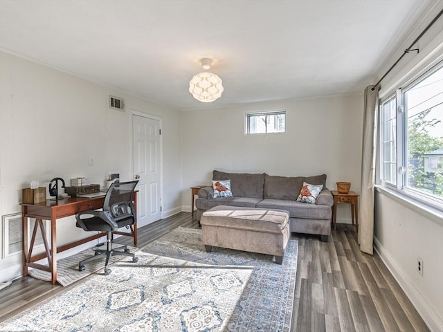 living room with a desk, wood finished floors, ornamental molding, and baseboards
