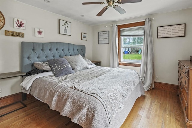 bedroom with baseboards, ceiling fan, and wood-type flooring