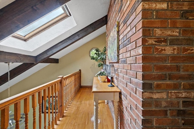 16 Gilbert Way, Millbury, MA 01527 - hallway featuring a skylight, wood finished floors, brick wall, and baseboards