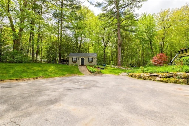 16 Gilbert Way, Millbury, MA 01527 - view of front facade featuring an outdoor structure, a front lawn, and a view of trees
