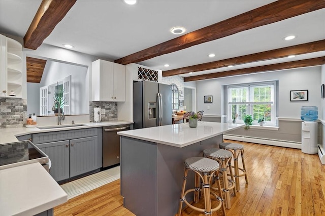 16 Gilbert Way, Millbury, MA 01527 - kitchen featuring a baseboard heating unit, stainless steel appliances, a sink, light wood-type flooring, and beamed ceiling