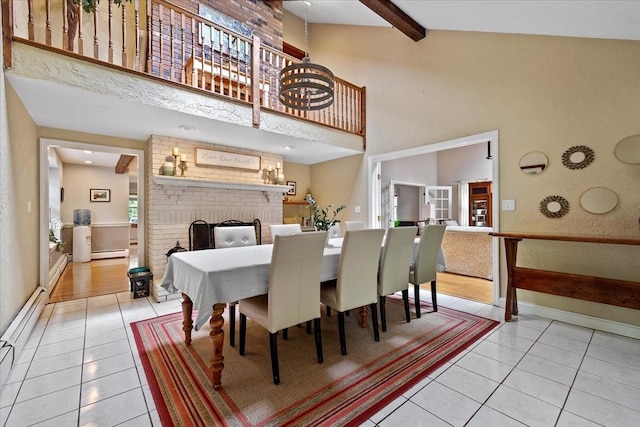 16 Gilbert Way, Millbury, MA 01527 - dining space with light tile patterned floors, a high ceiling, a baseboard radiator, a fireplace, and beamed ceiling