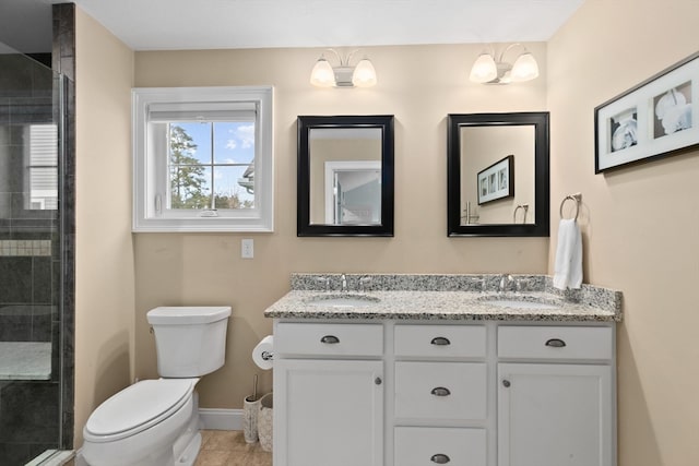 bathroom with tile patterned flooring, vanity, toilet, and a shower with shower door