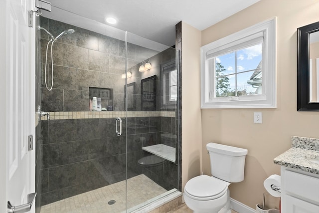 bathroom featuring vanity, an enclosed shower, and toilet