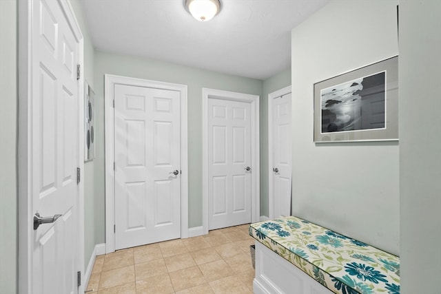 bedroom with light tile patterned flooring and multiple closets