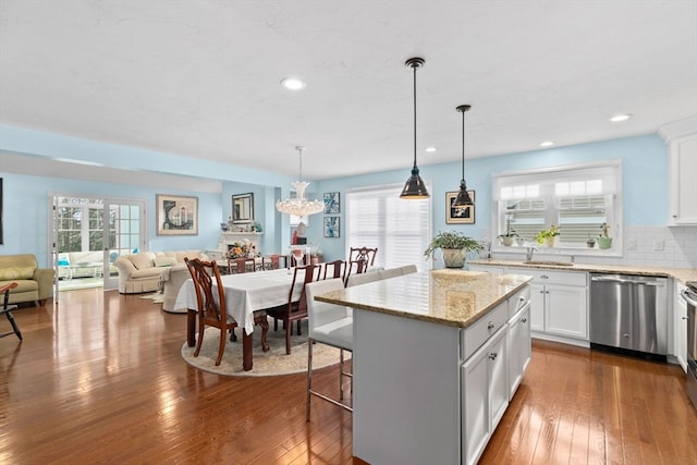 kitchen featuring dishwasher, dark hardwood / wood-style flooring, a kitchen island, and a wealth of natural light