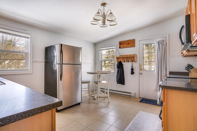 kitchen featuring lofted ceiling, freestanding refrigerator, dark countertops, and a baseboard radiator