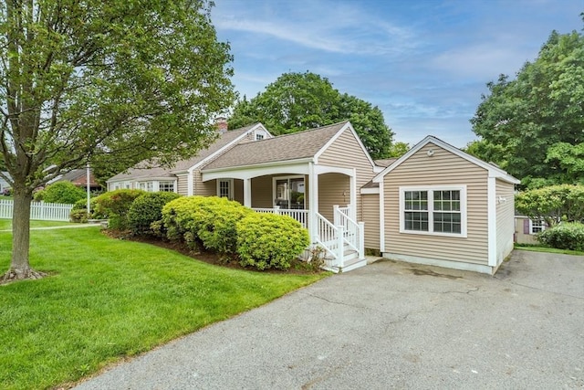 6 Gilbert Rd, Natick, MA 01760 - view of front of property with a front lawn, covered porch, a chimney, a shingled roof, and asphalt driveway