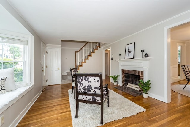 6 Gilbert Rd, Natick, MA 01760 - living area featuring stairway, light wood-type flooring, a brick fireplace, crown molding, and baseboards