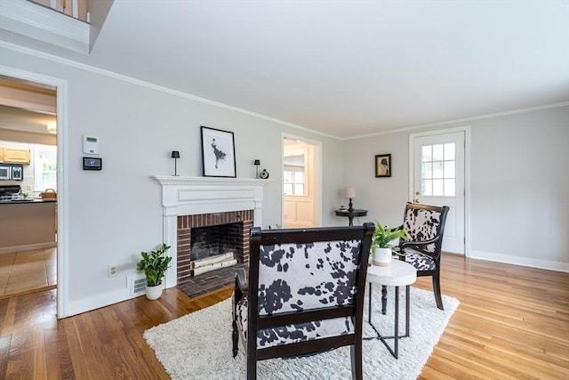 6 Gilbert Rd, Natick, MA 01760 - living area with light wood-type flooring, crown molding, a brick fireplace, and baseboards