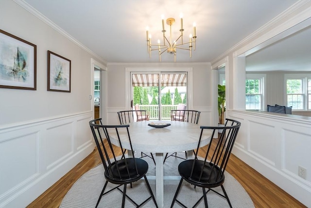 6 Gilbert Rd, Natick, MA 01760 - dining space featuring wood finished floors, a chandelier, a decorative wall, ornamental molding, and wainscoting