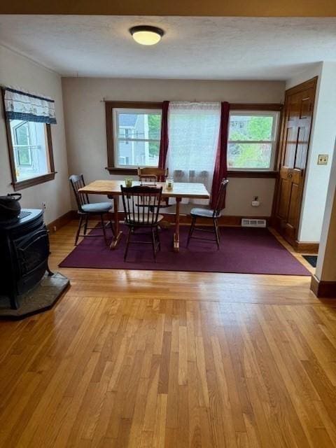 14 Pequot Rd, Weymouth, MA 02191 - dining area featuring a wood stove, plenty of natural light, light wood-type flooring, and baseboards