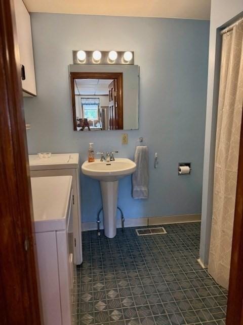 14 Pequot Rd, Weymouth, MA 02191 - full bathroom featuring a sink, baseboards, and washing machine and dryer