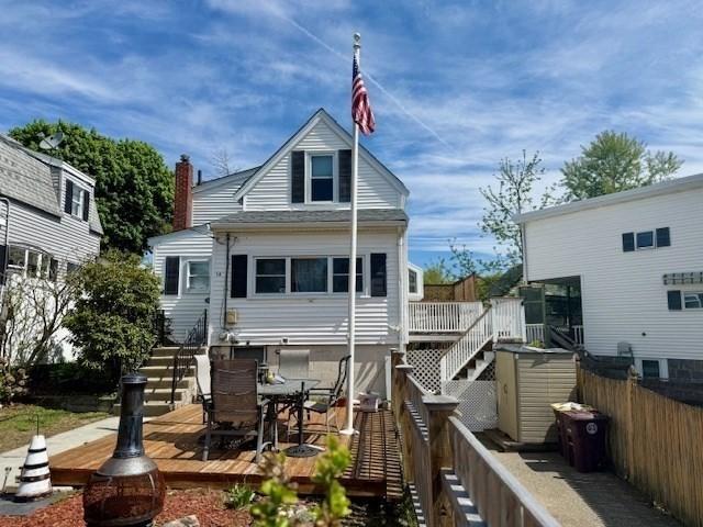 14 Pequot Rd, Weymouth, MA 02191 - back of property featuring stairway, a wooden deck, a fenced backyard, and outdoor dining area