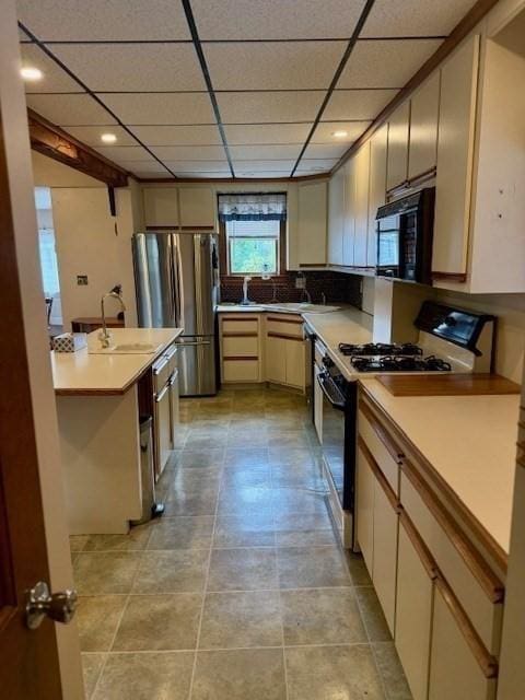 14 Pequot Rd, Weymouth, MA 02191 - kitchen with range with gas cooktop, black microwave, freestanding refrigerator, a sink, and a paneled ceiling