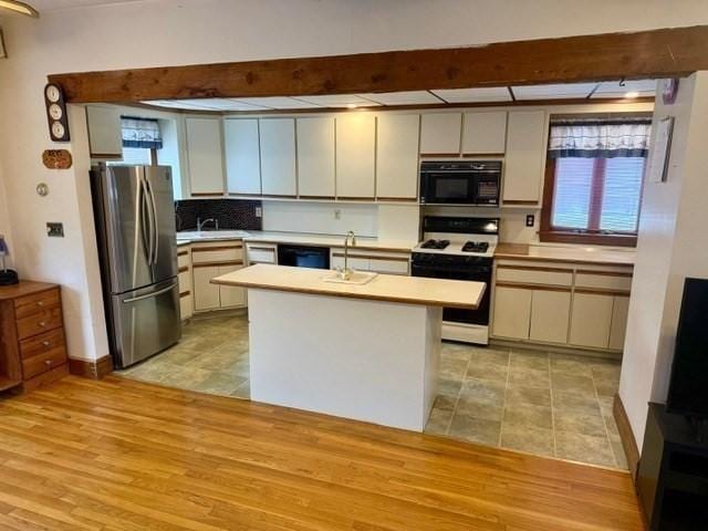 14 Pequot Rd, Weymouth, MA 02191 - kitchen with black appliances, light countertops, plenty of natural light, beam ceiling, and a sink