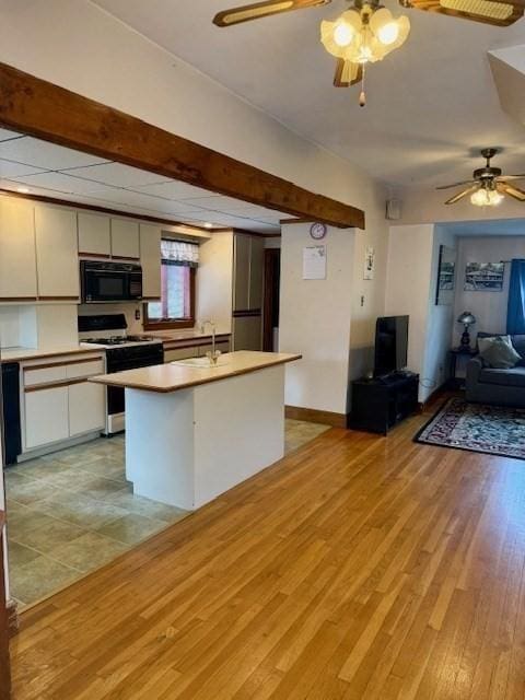 14 Pequot Rd, Weymouth, MA 02191 - kitchen featuring stove, black microwave, open floor plan, ceiling fan, and light wood-style floors