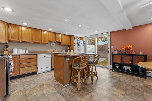 kitchen featuring a breakfast bar, white appliances, and a kitchen island