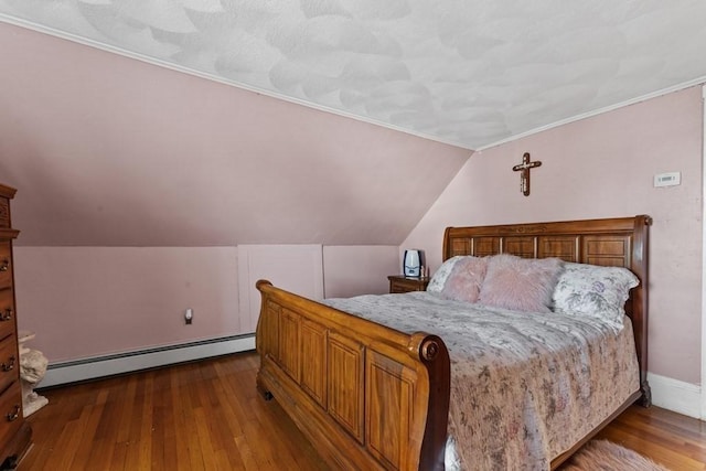 bedroom featuring lofted ceiling, a baseboard heating unit, and hardwood / wood-style flooring