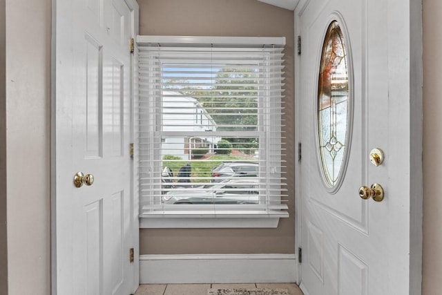 tiled entryway with lofted ceiling