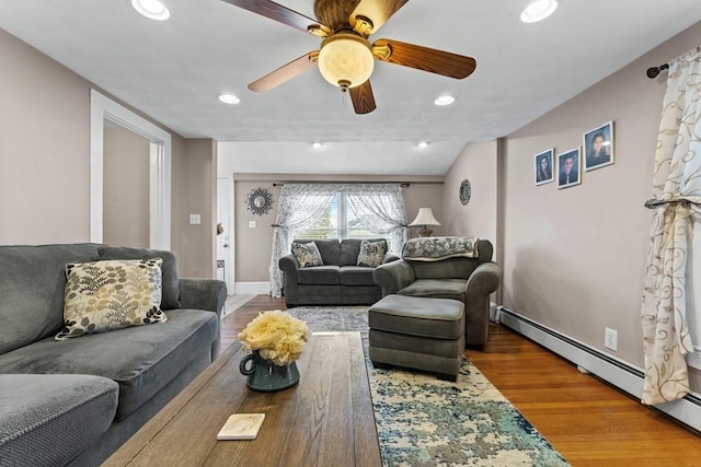 living room featuring a baseboard heating unit, ceiling fan, and hardwood / wood-style floors