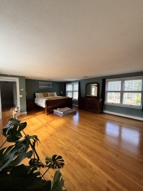 24 Congamond Rd, Southwick, MA 01077 - unfurnished bedroom featuring a baseboard radiator, light wood finished floors, and a textured ceiling