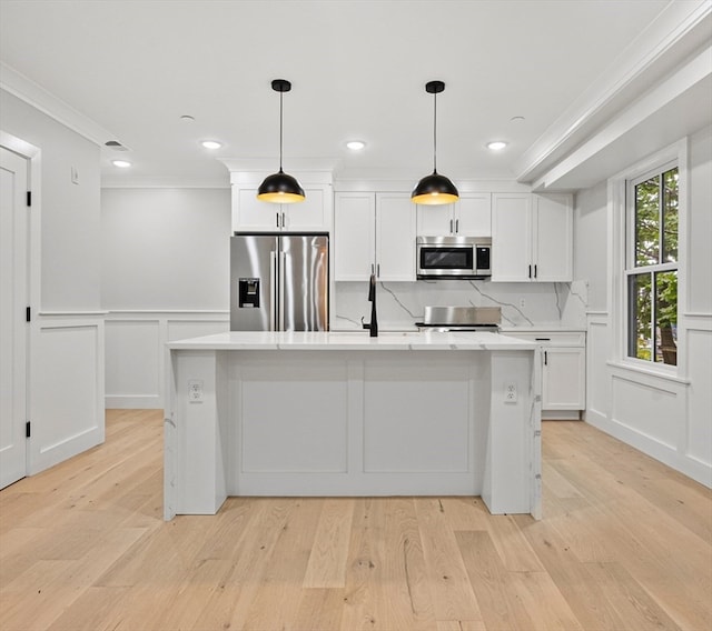 kitchen with a center island with sink, white cabinets, stainless steel appliances, and light hardwood / wood-style floors