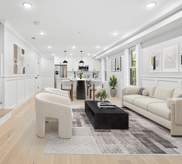 living room with crown molding and light hardwood / wood-style flooring