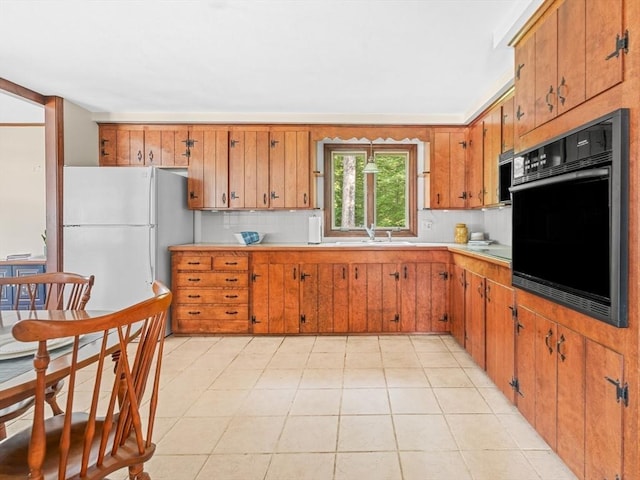 1 Winter Dr, Seekonk, MA 02771 - kitchen with black oven, freestanding refrigerator, brown cabinetry, and light countertops