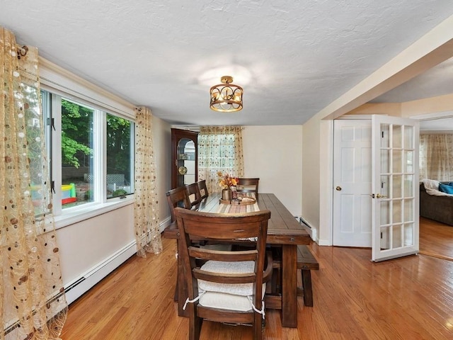 dining room featuring baseboard heating and light hardwood / wood-style flooring