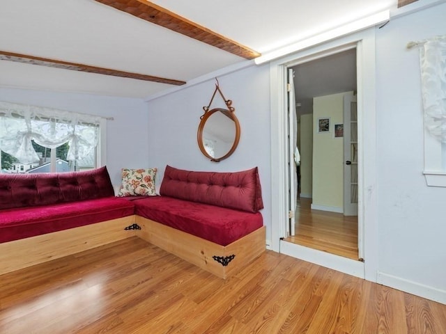 living room featuring beamed ceiling and hardwood / wood-style floors