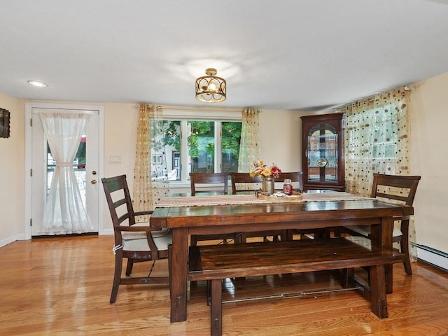 dining area with light hardwood / wood-style floors and an inviting chandelier