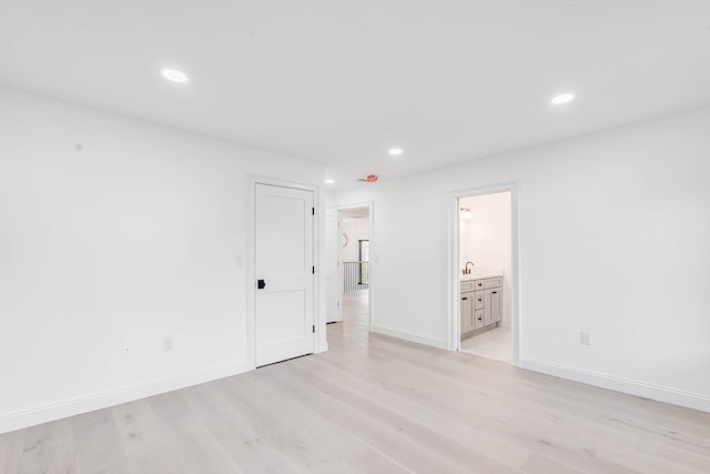 unfurnished room featuring light hardwood / wood-style flooring and sink