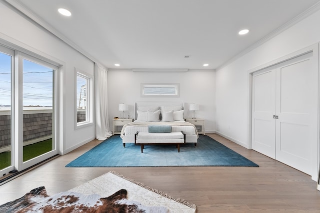 bedroom featuring hardwood / wood-style floors, access to outside, and ornamental molding