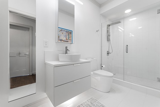 bathroom with tile patterned floors, toilet, a shower with door, vanity, and crown molding