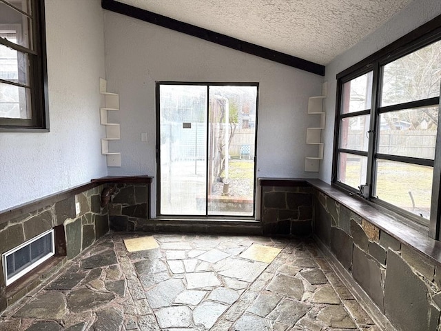 interior space with vaulted ceiling and a textured ceiling