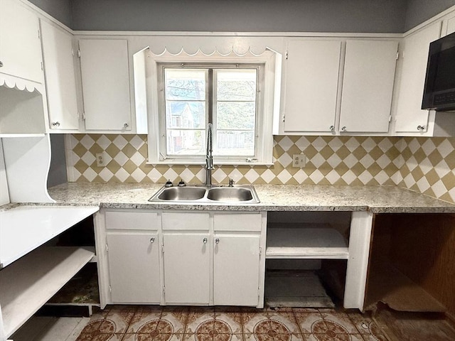 kitchen featuring white cabinetry, sink, and backsplash