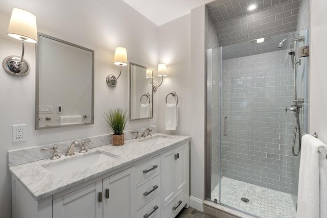 bathroom featuring a stall shower, double vanity, and a sink