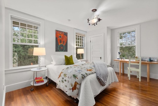 bedroom featuring wood-type flooring and baseboards