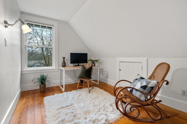 sitting room featuring baseboards, wood finished floors, and lofted ceiling