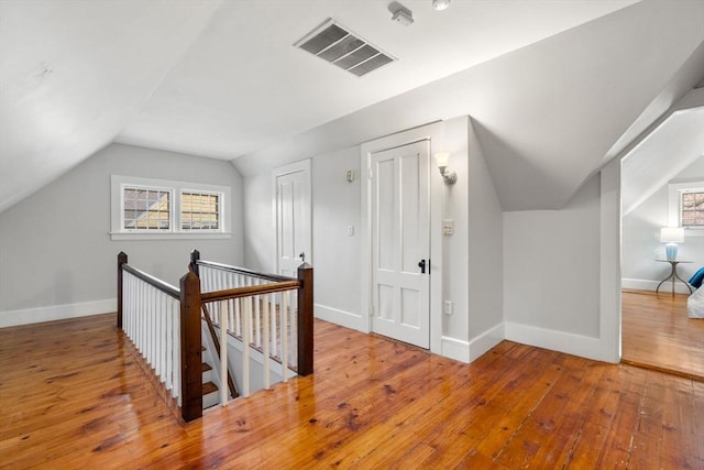 additional living space with visible vents, baseboards, wood-type flooring, and a wealth of natural light