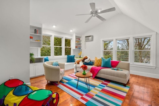 living area with light wood-style floors, a ceiling fan, vaulted ceiling, a wall mounted air conditioner, and baseboards