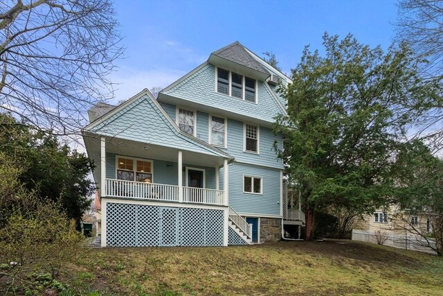 rear view of house featuring a yard, a chimney, stairs, and covered porch