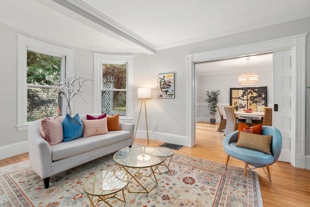 sitting room featuring ornamental molding, baseboards, an inviting chandelier, and light wood-style floors