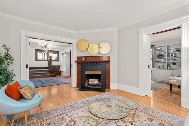 living room featuring a chandelier, crown molding, wood-type flooring, and stairway