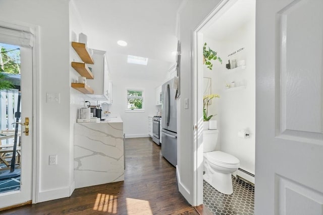 14 Turning Mill Ln Unit 14, Quincy, MA 02169 - bathroom featuring plenty of natural light, wood finished floors, a skylight, a baseboard heating unit, and recessed lighting