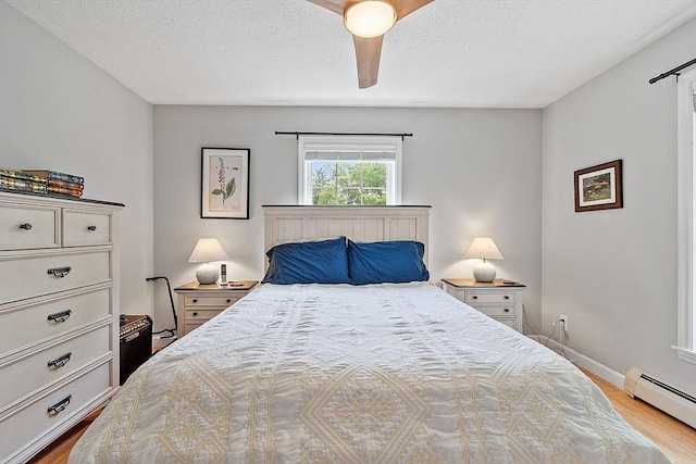 24 Joel Scott Dr, Holden, MA 01520 - bedroom featuring a baseboard heating unit, wood finished floors, a ceiling fan, baseboards, and a textured ceiling