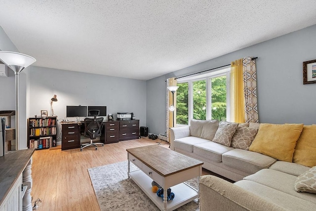 24 Joel Scott Dr, Holden, MA 01520 - living area with light wood-type flooring, a desk, a textured ceiling, and a baseboard heating unit
